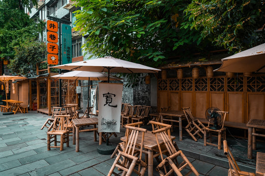 Outdoor cafe seating with wooden chairs and tables.
